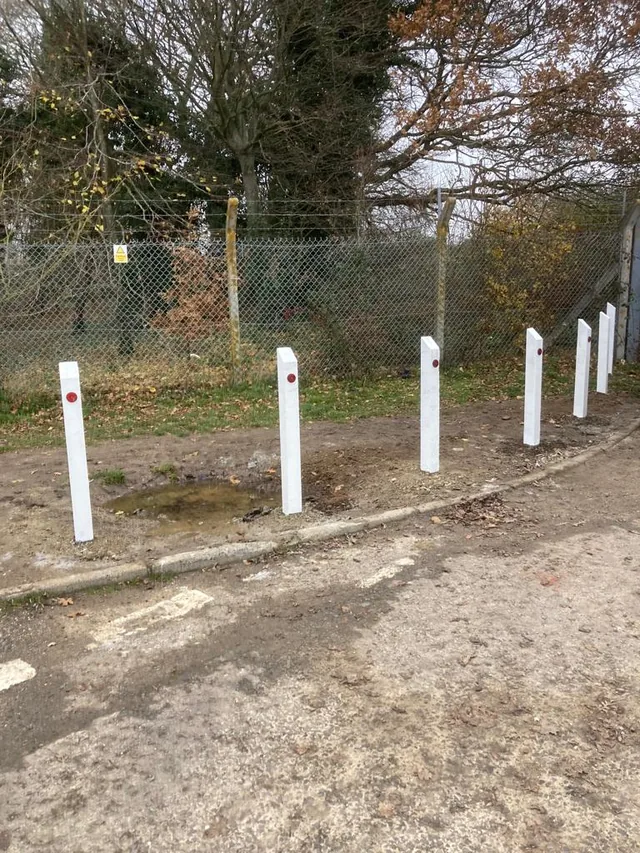 White boundary posts with red reflectors beside a road