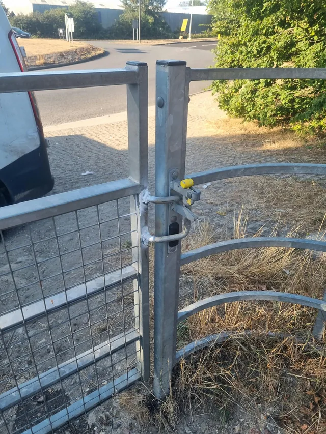 Close view of a steel gate latch and its connection to a post