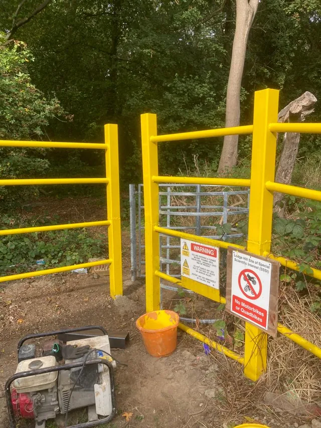 Yellow steel rails and a gate with work materials still alongside