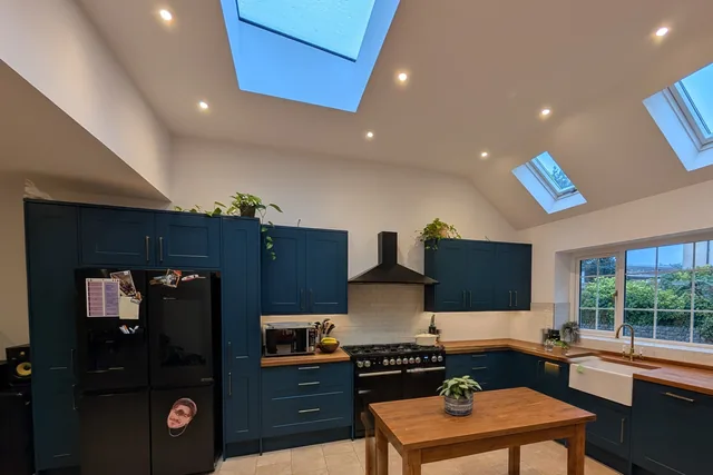 Blue kitchen cabinetry beneath the extension rooflights