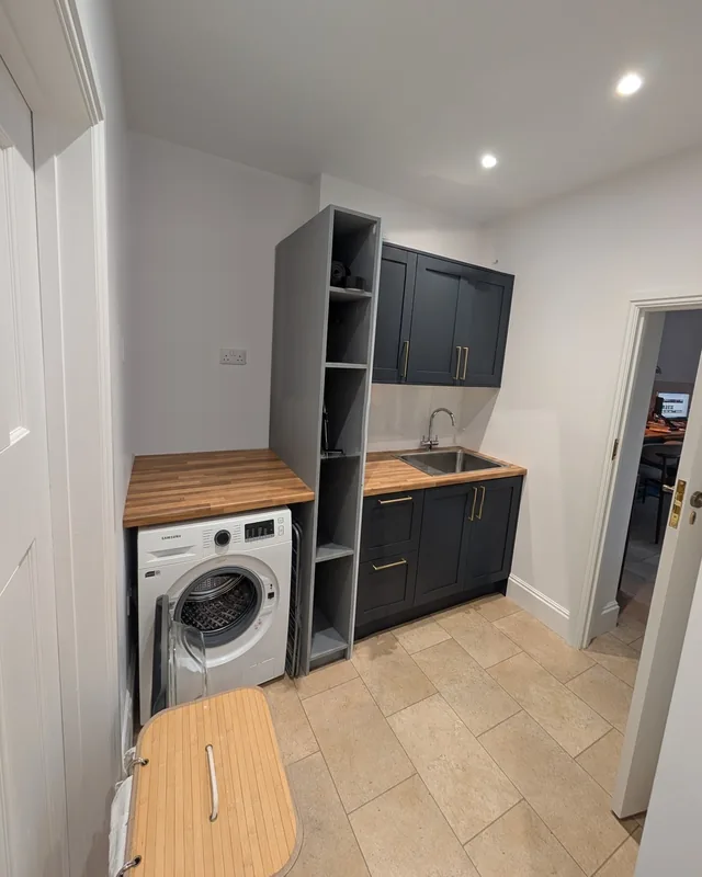 Utility space with fitted cabinetry and a washing machine
