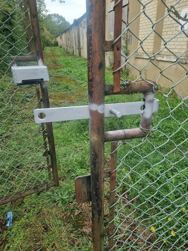 Galvanised latch and locking hardware on a chain-link gate