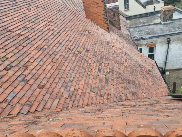 Red tiled roof with intersecting slopes and brick chimneys in Dover