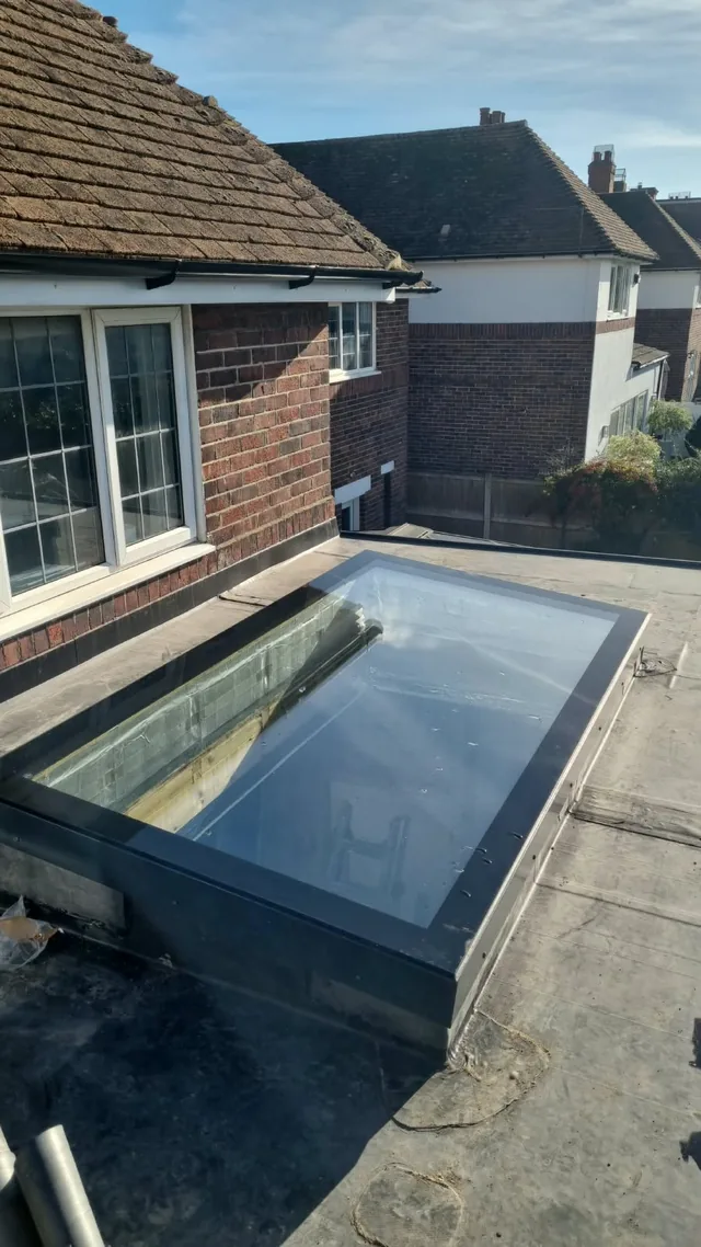 Rectangular rooflight in a flat roof beside a house