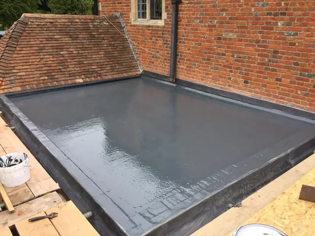 Flat roof at a brick building with tools and work materials alongside