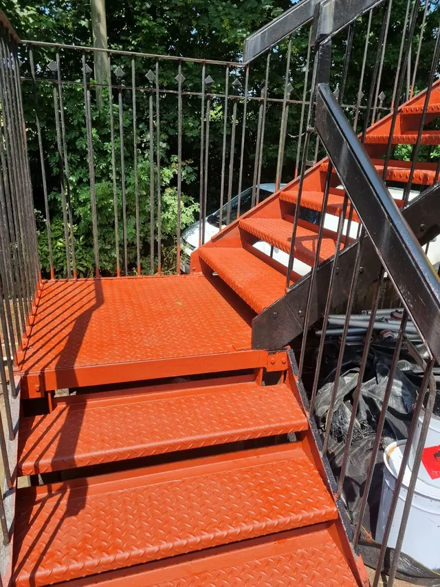 Orange-coated tread panels and landing on an external staircase