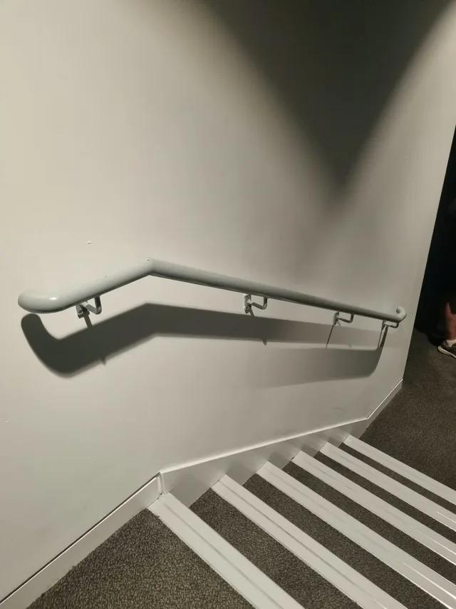 Steel wall-mounted handrail following a change in stair direction at the Marlowe Theatre
